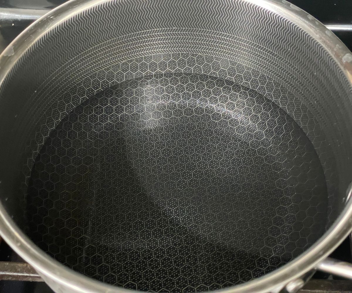 A pot of water is on the stove top.