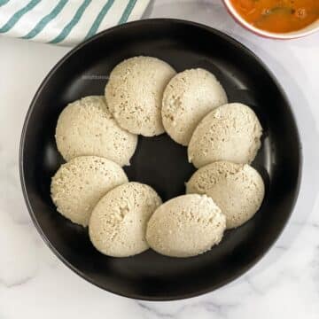 A plate of quinoa idlis are on the table.