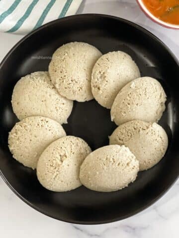A plate of quinoa idlis are on the table.