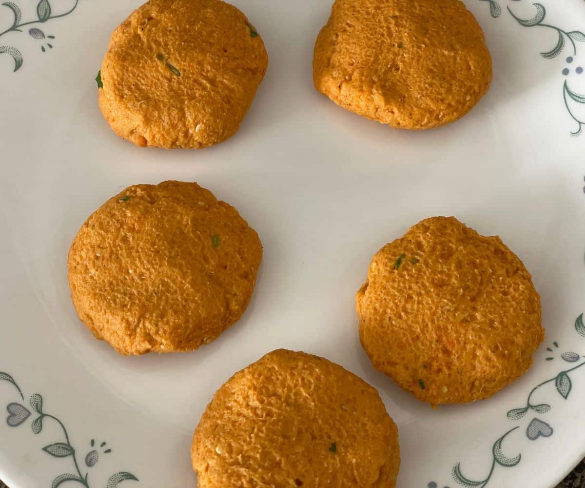 A plate has four sweet potato patties.