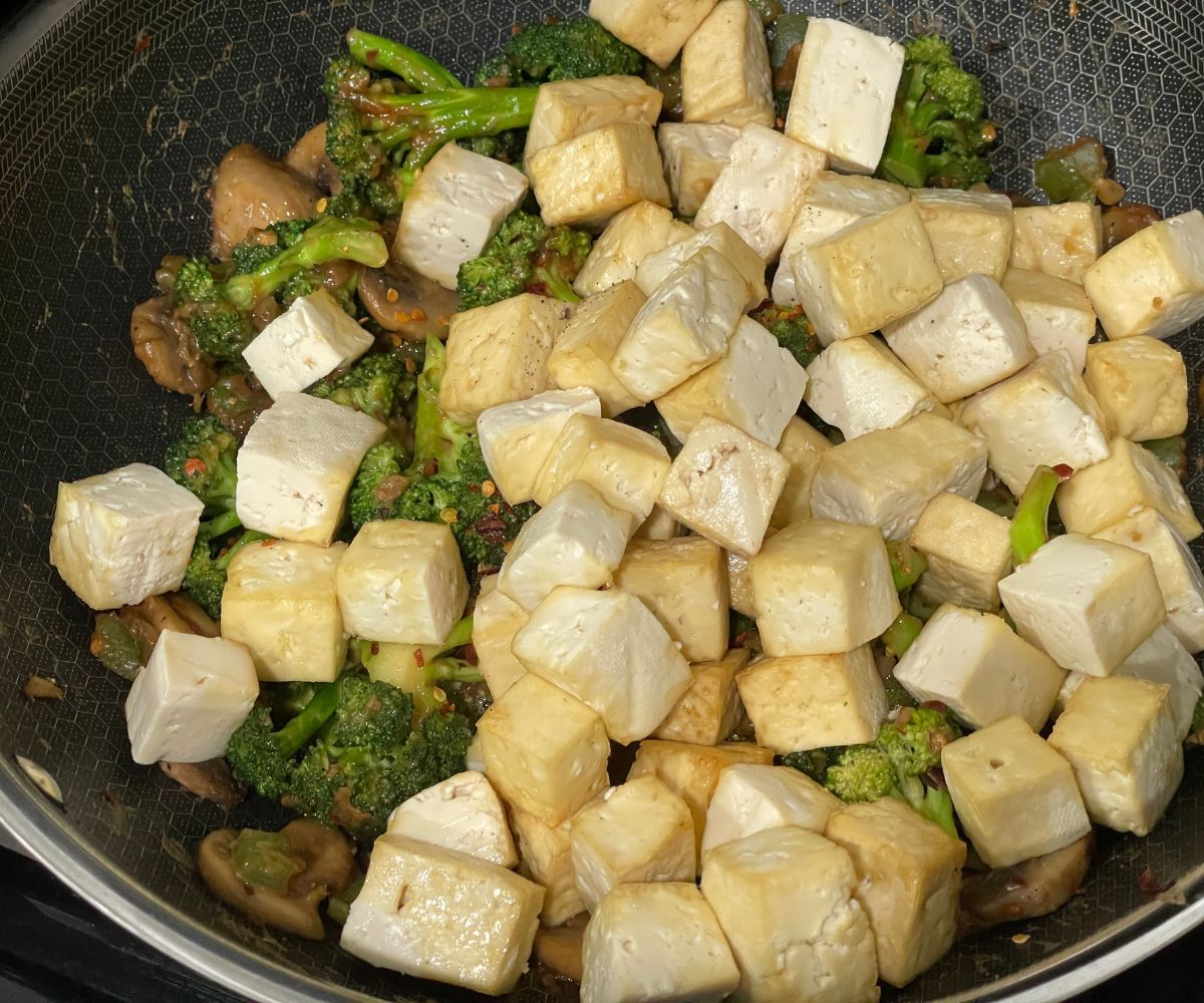 A pot is full of tofu broccoli mushroom stir fry.