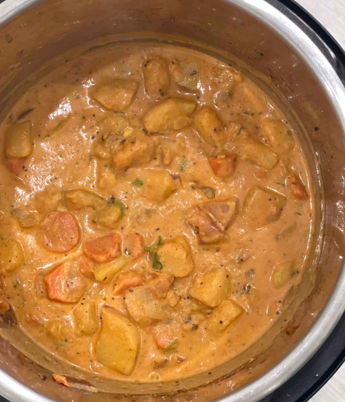 An instant pot has vegan potato curry.