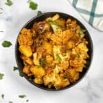 A bowl is full of cauliflower and potato curry.
