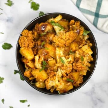 A bowl is full of cauliflower and potato curry.