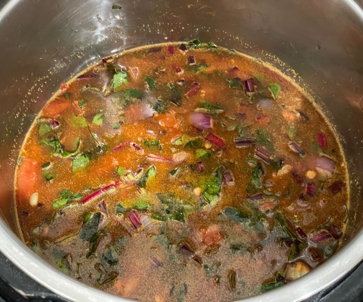 An instant pot has all the ingredients for beetroot leaves dal.