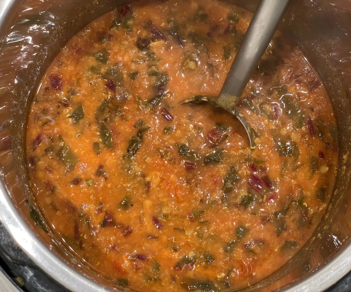 An Instant pot filled with beetroot leaves dal.