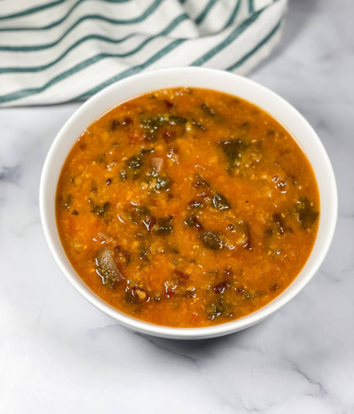 A bowl of beet greens dal is on the table.