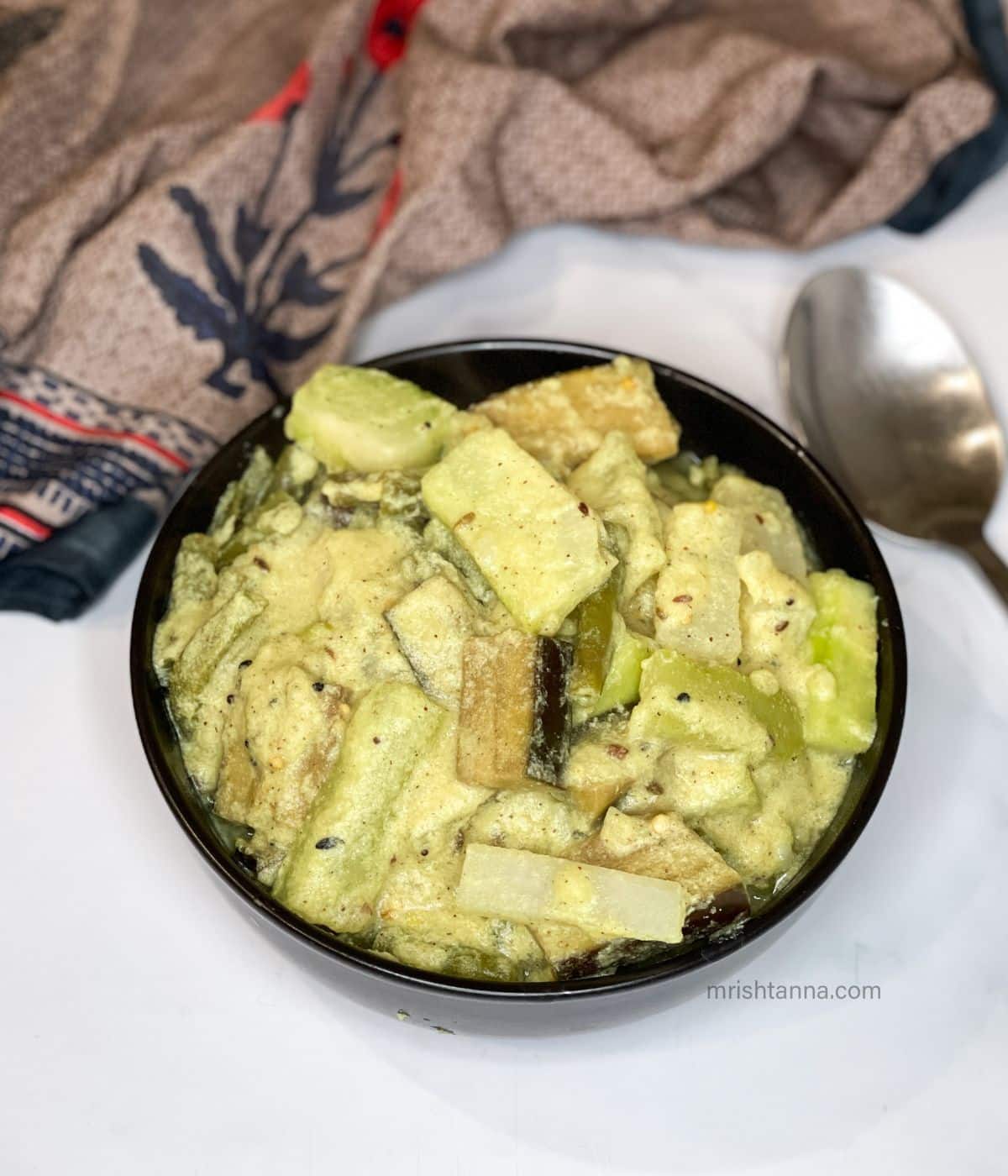 A bowl of Bengali mixed vegetable curry is on the surface.