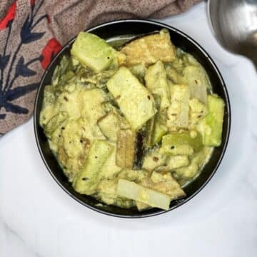 A bowl of Bengali shukto curry is on the table.