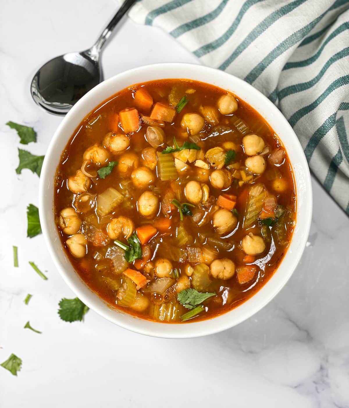 A bowl of garbanzo soup is on the table.