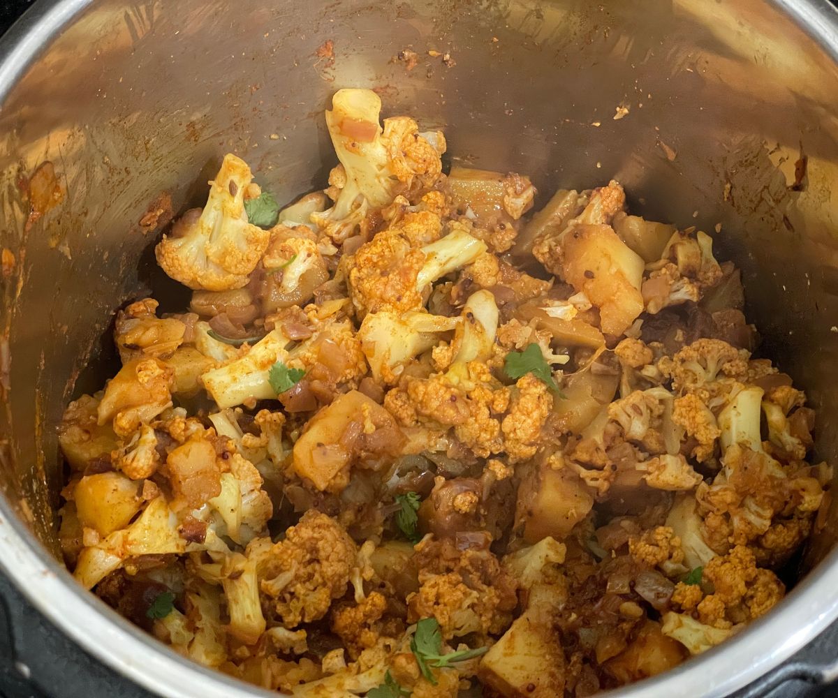 An instant pot is filled with aloo gobi masala.