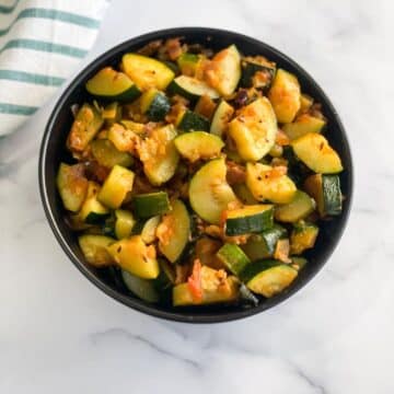 A bowl of zucchini sabzi is on the table.