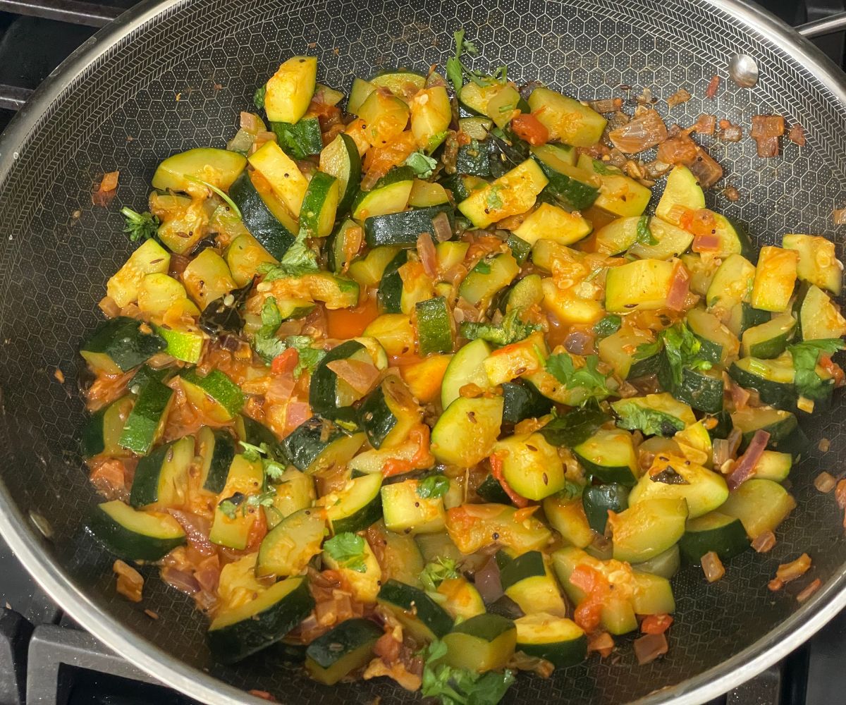 A pan has zucchini Indian stir fry.