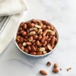 A bowl has roasted peanuts.
