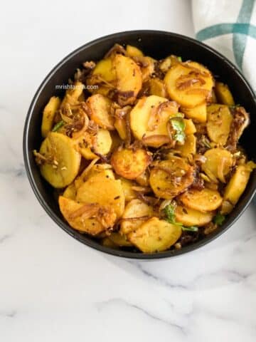 A bowl of sweet potato Indian recipe is on the table.
