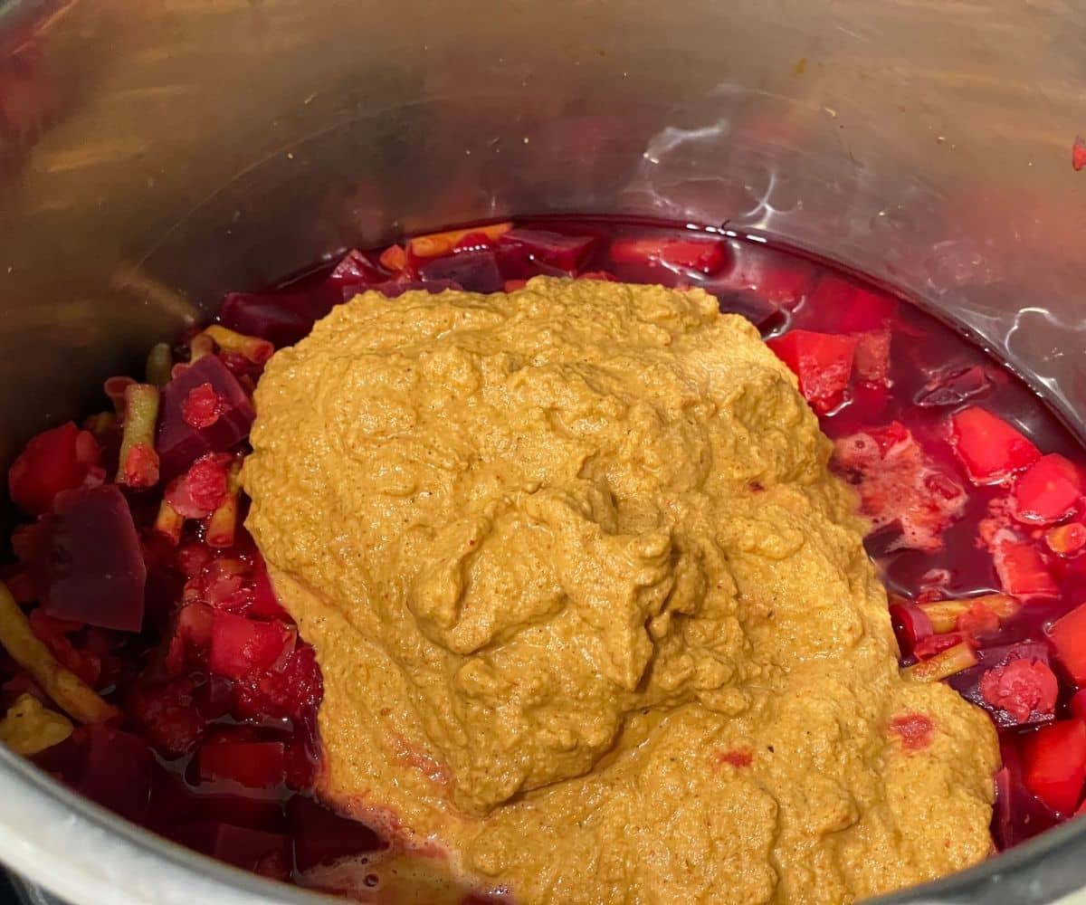 A pot is with vegetables and blended coconut mixture.