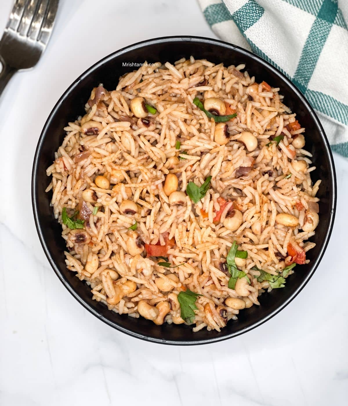 A bowl of black eyed peas rice on the table.