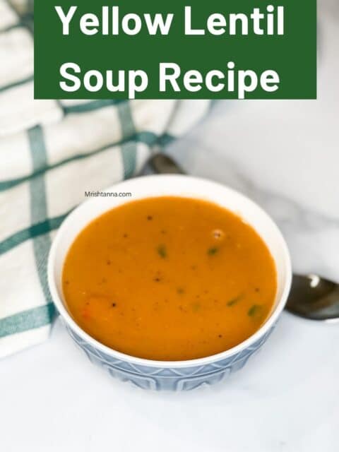 A bowl of yellow Lentil vegan soup is on the table.