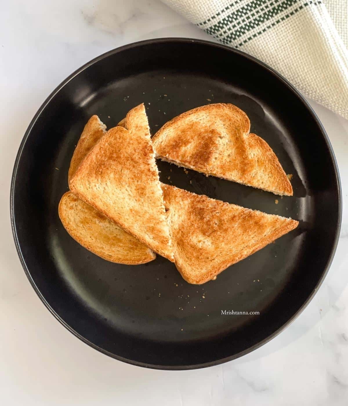 A plate of air fryer peanut butter jelly sandwiches are on the table.