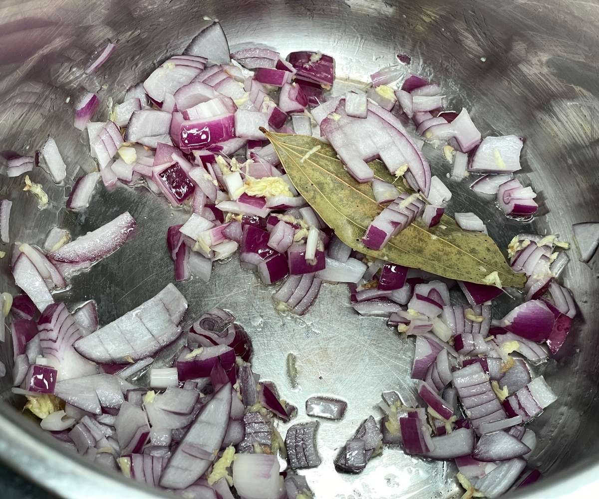 An instant pot has spices and onions on saute mode.