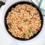 A bowl of black eyed peas rice is on the table.