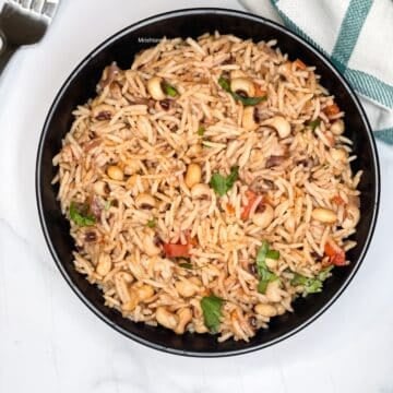 A bowl of black eyed peas rice is on the table.
