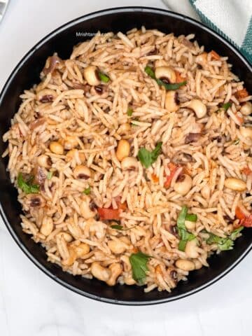 A bowl of black eyed peas rice is on the table.