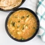 A bowl of zucchini dal is on the surface.