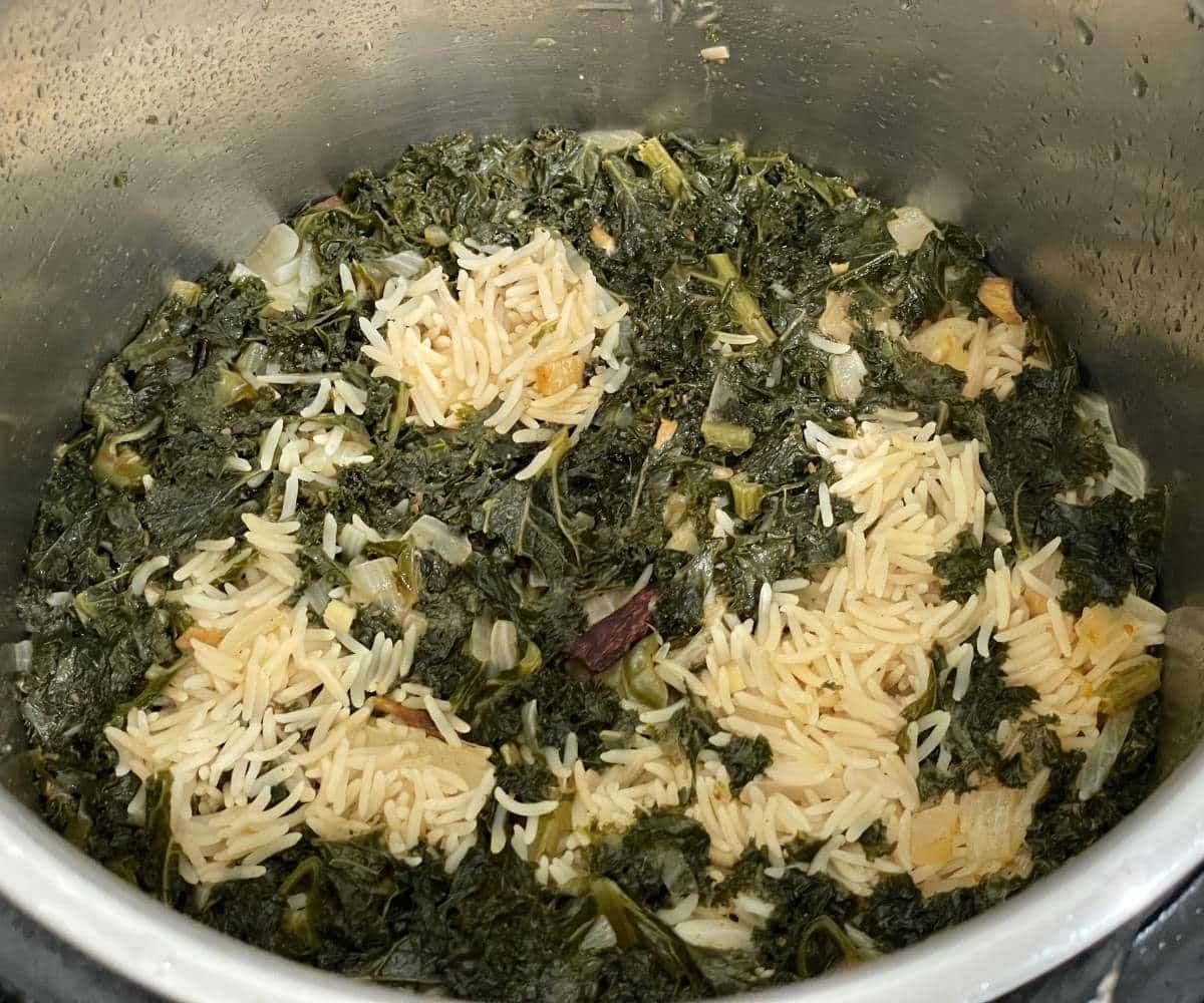 An instant pot has cooked kale rice.