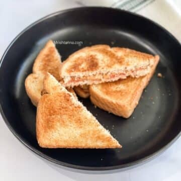 A plate is full of peanut butter jelly sandwiches.