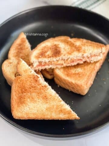 A plate is full of peanut butter jelly sandwiches.