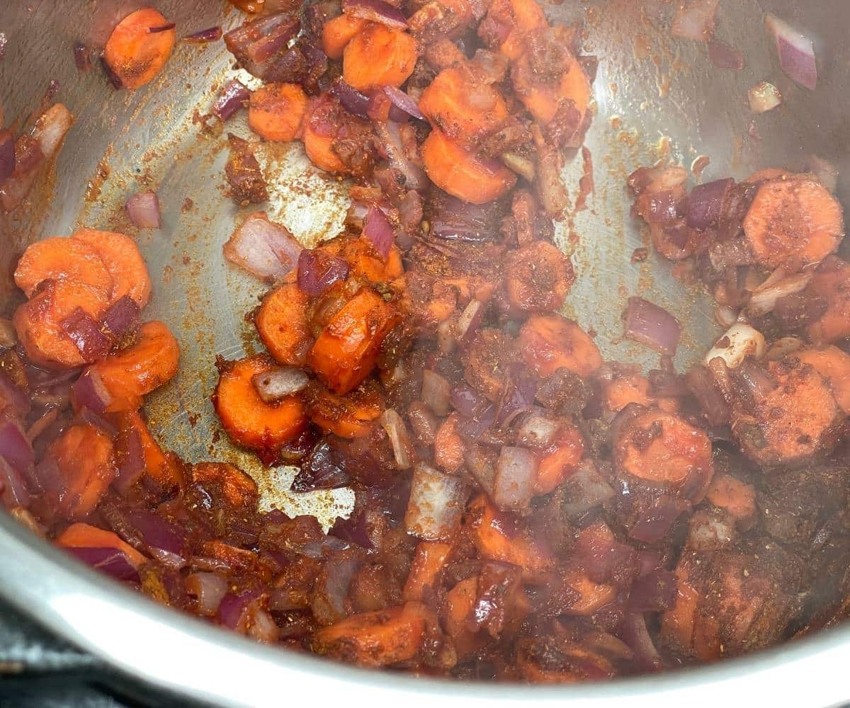 A pot has carrots and spices.