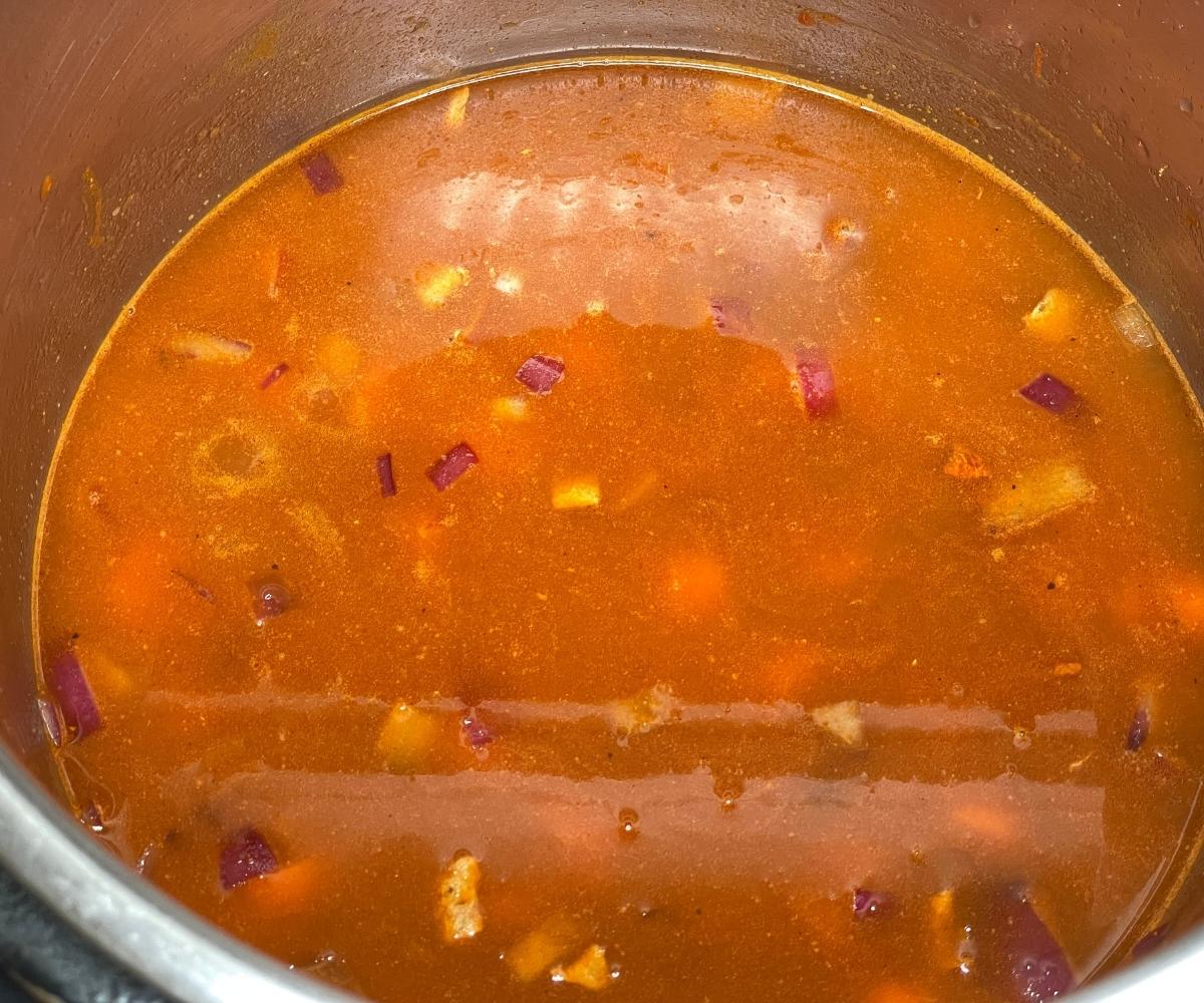 A pot is with yellow Lentil soup ingredients.