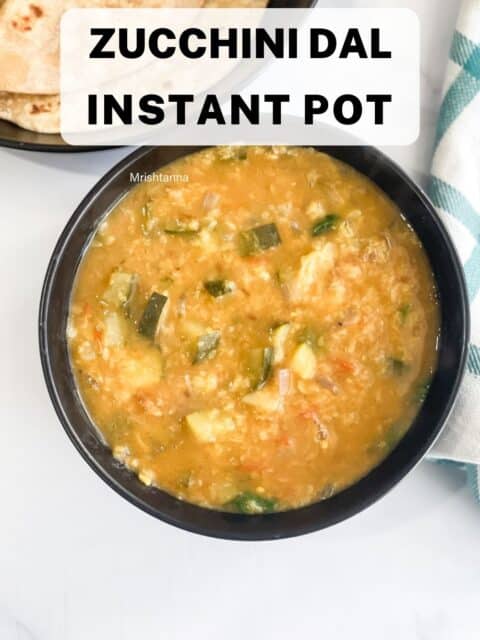 A bowl is with zucchini dal on the table.