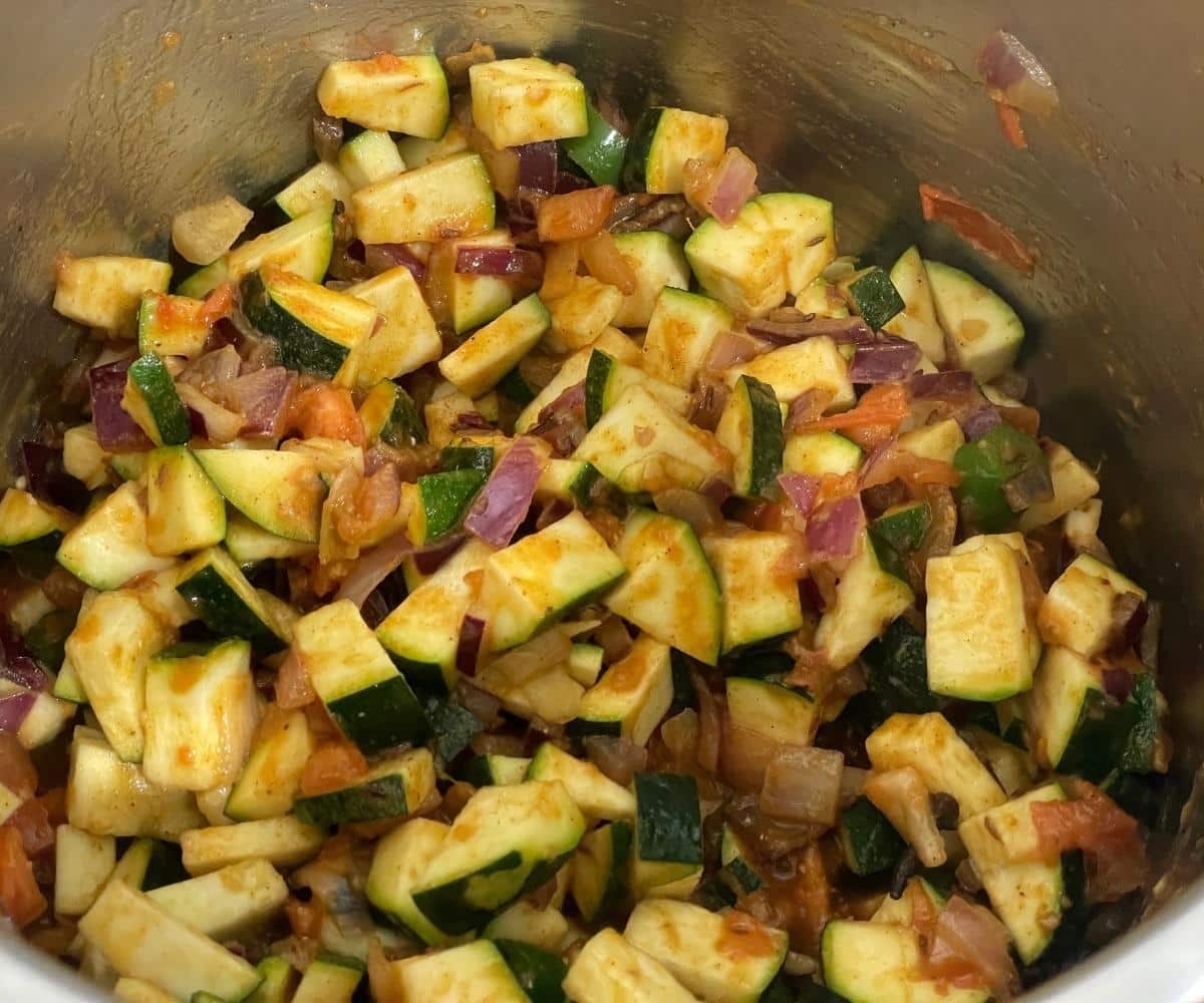 An instant pot has zucchini and lentils for dal.