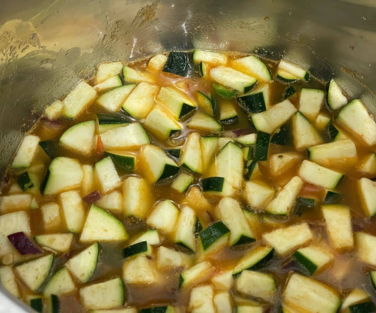 A pot has all the zucchini dal ingredients.