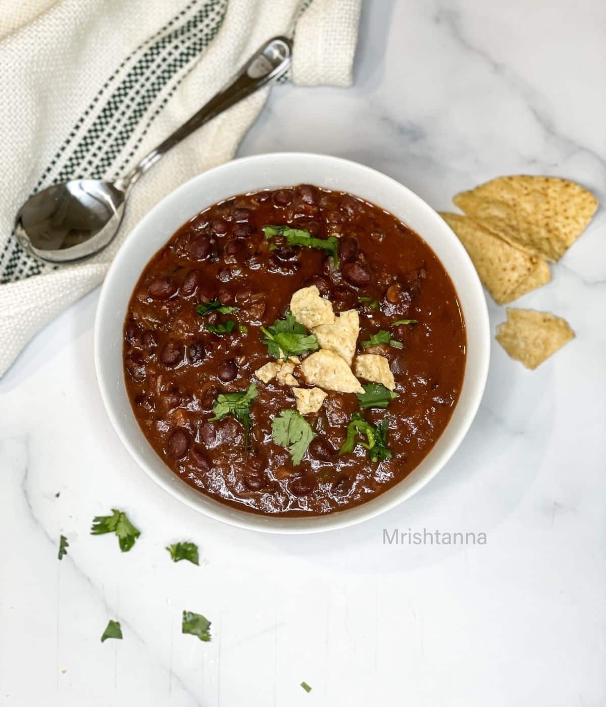 A bowl of instant pot black bean soup is on the table.