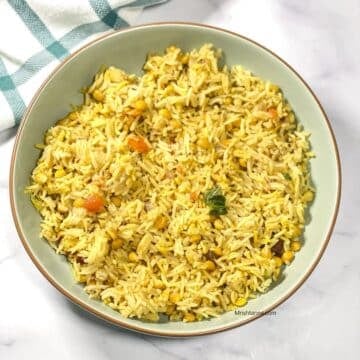 A plate of dal Pulao is on the marble table.