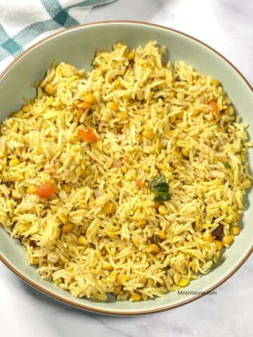 A plate of dal Pulao is on the marble table.
