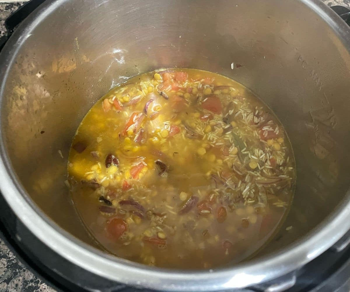 A pot is with Chana dal pulao ingredients to pressure cook.