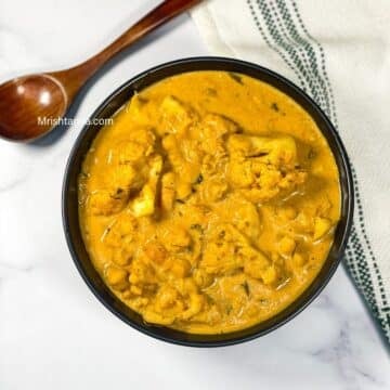 A bowl of vegan gobi tikka masala curry is on the table.