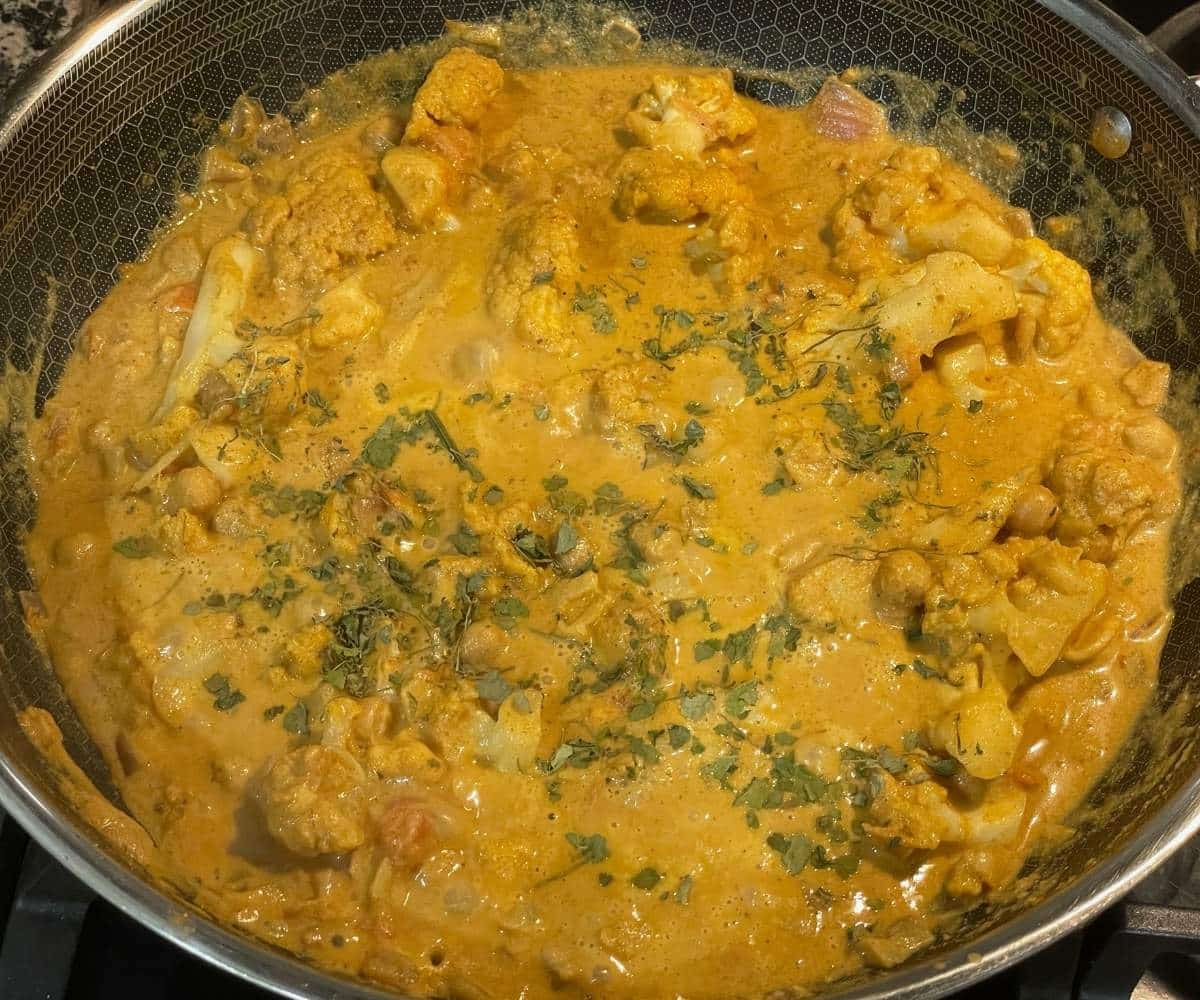 A pan is filled with vegan cauliflower tikka masala curry.